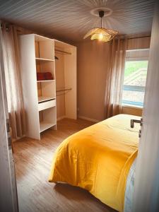 a bedroom with a yellow bed and a window at La Tanière du Katz in Dabo +7 photos