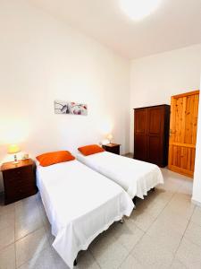 2 łóżka w pokoju z białymi ścianami w obiekcie Residence La Cinta 8 w mieście San Teodoro