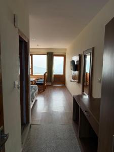 a hotel room with a bedroom with a view of the ocean at Cedar Valley Retreat in Jagatsukh