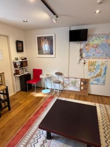 a living room with a table and a map on the wall at Kanazawa Guesthouse Stella in Kanazawa
