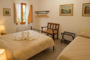 a bedroom with two beds and a chair at Casa di Aonio Paleario in Colle di Val d'Elsa