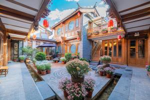丽江Shile Inn的一组种有盆栽和花卉的建筑