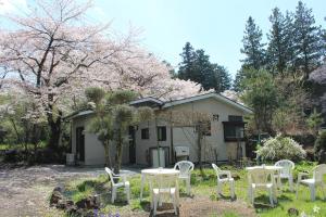 a group of white chairs and tables in front of a house at Nishimiyasou in Fujikawaguchiko