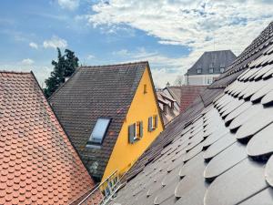 a yellow building sitting on top of roofs at Schatzsuche im Altstadthaus 2 Grad Nähe Legoland in Günzburg