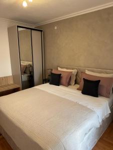 1 dormitorio con 1 cama grande con almohadas rosas y negras en Apartments Ivusic, en Hvar