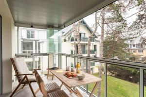 un balcone con tavolo e sedie e una grande finestra di Les pins #208 - 6min à pied de la plage a Fréhel