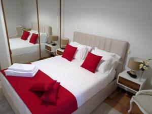 a bedroom with two beds with red and white pillows at Casa de Ladrido in Felgueiras +82 photos