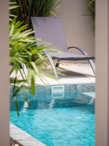 ラワイビーチにあるLeivi Villa 3 bedroomsのプールの上の椅子に置かれたノートパソコン