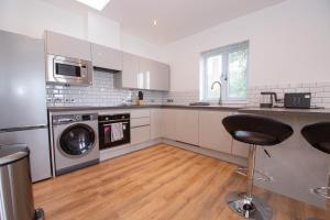 a kitchen with a washing machine and a washer at Affleck Retreat 5 - SJA Stays - Modern 1 Bed Apartment in Aberdeen