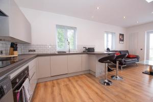 a kitchen with white cabinets and a counter top at Affleck Retreat 5 - SJA Stays - Modern 1 Bed Apartment in Aberdeen