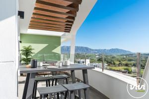 a balcony with a table and chairs and a view at VIVI Homes - Bonita del Sol Beach, Pool, Garden, GYM & SPA in La Cala de Mijas +28 photos