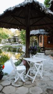 two white chairs and a table and an umbrella at The Little Garden Mui Ne Homestay in Mui Ne +35 photos
