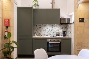 a kitchen with green cabinets and a stove at Groundfloor Harbour Loft in Senglea