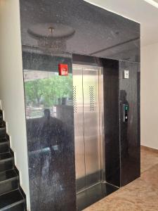 an elevator in a building with a man standing in the doorway at Hotel Garden View - Mansarovar in Jaipur