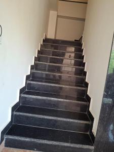 a set of stairs in a building with black at Hotel Garden View - Mansarovar in Jaipur