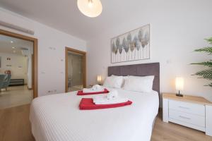 a bedroom with a white bed with towels on it at Flor do Galvão in Lagos +25 photos