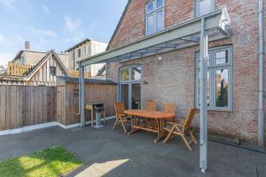 a patio with a wooden table and chairs at Stadthuus 51 in Husum