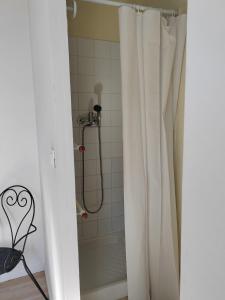 a shower with a white shower curtain in a bathroom at La Golondrina in Villefranche-sur-Saône
