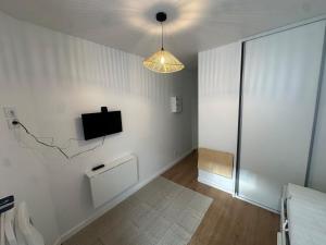 a living room with a tv on a white wall at Studio refait à neuf, lumineux - 131 in Dax