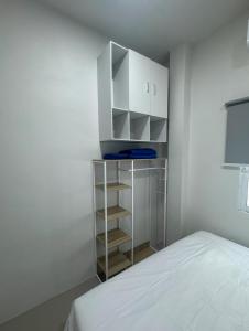 a bedroom with a bed and a white cabinet at The Little House in Chaloklum
