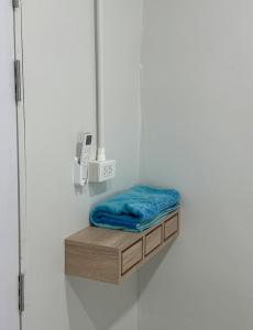 a small shelf with a blue pillow on a wall at The Little House in Chaloklum