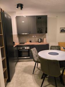a kitchen with a table and chairs in a room at COMODO "Green Hill" in Soko Banja