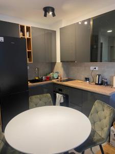 a kitchen with a white table and chairs at COMODO "Green Hill" in Soko Banja