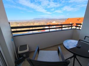 a balcony with a table and chairs and a view at COMODO "Green Hill" in Soko Banja