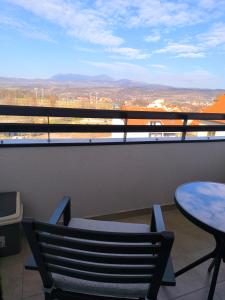a balcony with a table and chairs and a view at COMODO "Green Hill" in Soko Banja