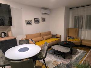 a living room with a couch and a table at COMODO "Green Hill" in Soko Banja