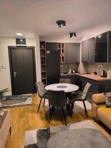 a kitchen and living room with a table and chairs at COMODO "Green Hill" in Soko Banja
