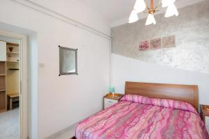 a bedroom with a bed with a pink blanket at La Finestra sul Mare in Genoa