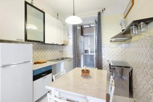 a kitchen with a white refrigerator and a table at La Finestra sul Mare in Genoa