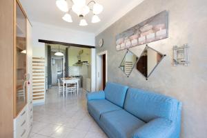 a living room with a blue couch and a kitchen at La Finestra sul Mare in Genoa