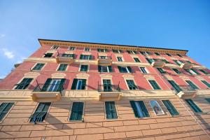 a tall red brick building with windows and balconies at La Finestra sul Mare in Genoa