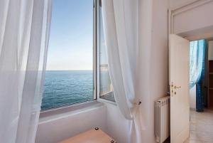 a room with a window with a view of the ocean at La Finestra sul Mare in Genoa