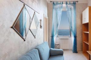 a living room with a blue couch and a window at La Finestra sul Mare in Genoa