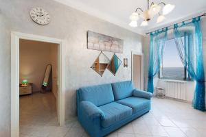 a blue couch in a living room with a clock at La Finestra sul Mare in Genoa