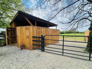 un fienile in legno con cancello e recinzione di Rustic Charm Cabin a Naas