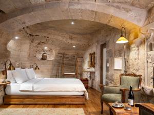 Un dormitorio con una cama y una pared de piedra. en Kelebek Special Cave Hotel & Spa, en Göreme 262 fotos más