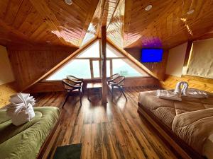 a room with a large window and a table and chairs at Attic cozy retreat by high rise inn kufri in Kūfrī +14 photos