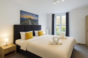 a bedroom with a large bed with two white towels at Sonnenschein Appartement in Wuppertal in Wuppertal
