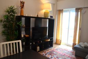 a living room with a television on a black entertainment center at JAM Retreat in Lisbon