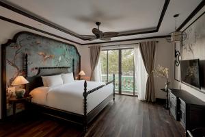 a bedroom with a bed and a large window at The An Bang Vanessa - Indochine Boutique Hotel in Hoi An