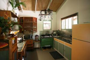 cocina con armarios verdes y nevera verde en Tropical Bliss bed and breakfast en Mena Creek