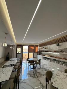 a restaurant with tables and chairs in a room at VagAthan - Lux Holidays in Afitos