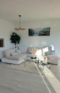 a living room with a white couch and a table at Vineyard-Suites Traumferienwohnung mit Panoramablick und Weinidylle in Elsenfeld