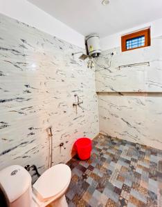 a bathroom with two toilets and a marble wall at Anandmay Homestay, Near Triveni Ghat, Rishikesh in Rishīkesh