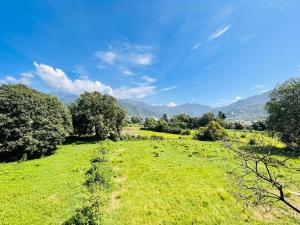a field of green grass with mountains in the background at Anandmay Homestay, Near Triveni Ghat, Rishikesh in Rishīkesh