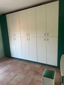 a room with white cabinets and a green wall at Villa canty in Nea Potidaea